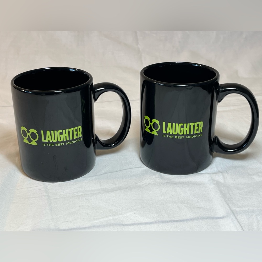 2 black ceramic mugs with phrase “laughter is the best medicine.” EUC